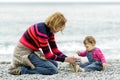 Baby girl and her mother playing with pebbles Royalty Free Stock Photo