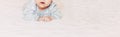 Baby girl on her stomach. Looking up with surprised expression. long banner Royalty Free Stock Photo