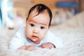 Baby girl on her stomach. Looking up with surprised expression. Royalty Free Stock Photo