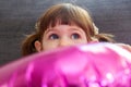 Baby girl hiding behind purple balloon Royalty Free Stock Photo