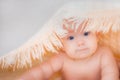 Baby girl is hiding under the coral blanket. Newborn under a blanket on a soft white background. Baby care. Skin care Royalty Free Stock Photo