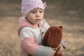 Baby girl holdong a bear toy in the outdoors Royalty Free Stock Photo