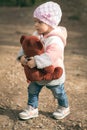 Baby girl holdong a bear toy in the outdoors Royalty Free Stock Photo