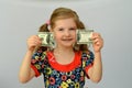 Baby girl holds in hands a torn banknote ,dollar ,banking crisis. Royalty Free Stock Photo