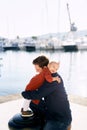 Baby girl is hugging her daddy while having a family day by the sea Royalty Free Stock Photo