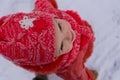 Baby girl impressed with the snow. Close-up. Top view