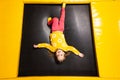 Baby girl kid lies upside down on trampoline at playground park. Child in motion during active entertaiments Royalty Free Stock Photo