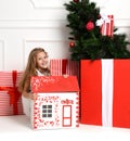 Baby Girl Kid playing with christmas red house in play room at home or kindergarten with little dolls toys Royalty Free Stock Photo