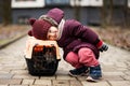 Baby girl with kitten in travel plastic cage carriage outdoor at park Royalty Free Stock Photo