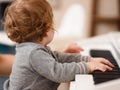 Baby girl learning to play the piano. Mom teaches the child to play the piano. Selective focus on children Royalty Free Stock Photo