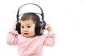 A baby girl listens music with headphone with hands Royalty Free Stock Photo