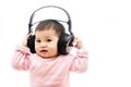 A baby girl listens music with headphone with hands Royalty Free Stock Photo