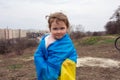 A baby girl with little sister with a flag of Ukraine against the backdrop of a city and a lake in a Ukrainian city