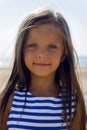 Baby girl with long hair in striped blue dress Royalty Free Stock Photo