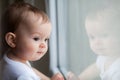 Baby girl looking through the window Royalty Free Stock Photo