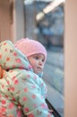 Baby girl looking through the window of a train