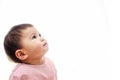 A baby girl looks up with pink clothes, not looking camera