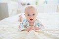 Baby girl lying on bed and smiling Royalty Free Stock Photo