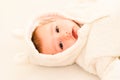 Baby girl lying on a white bed, adorable looking at camera