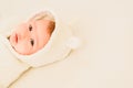 Baby girl lying on a white bed, adorable looking at camera