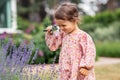 baby girl with magnifier looking at garden flowers Royalty Free Stock Photo