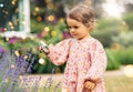 baby girl with magnifier looking at garden flowers Royalty Free Stock Photo