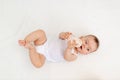 Baby girl 6 months old drinking milk from a bottle, lying on the bed in the nursery, feeding the baby, baby food concept Royalty Free Stock Photo