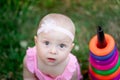 Baby girl 10 months old sitting on the grass in the summer and playing pyramid, early development of children, outdoor games Royalty Free Stock Photo