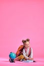 Baby girl with notebook globe and backpack on pink background smiling Royalty Free Stock Photo