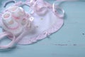 Baby girl nursery bib and booties on vintage blue background Royalty Free Stock Photo