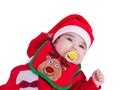 Baby girl with pacifier or dummy, red babygrow or onesie, Rudolph reindeer bib, Santa Claus hat Royalty Free Stock Photo