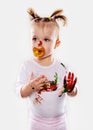 The baby girl with a pacifier in gouache soiled hands and shirt isolated