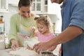 Baby girl with parents preparing food