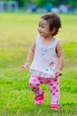 Baby Girl in the park, The first step on the grass with smiley Royalty Free Stock Photo