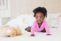 Baby girl in pink babygro crawling on bed Royalty Free Stock Photo