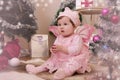 Baby girl with pink butterfly wings sitting under Christmas tree Royalty Free Stock Photo