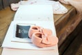 Baby girl pink dress clothes with newborn book album, body and little shoes and ultrasound scanning fetal photo
