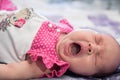 Baby girl in a pink dress funny yawning Royalty Free Stock Photo