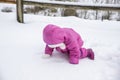 Laughing baby girl lying in deep snow Royalty Free Stock Photo