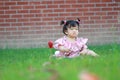 Baby girl play on the lawn, unhappy, miss her mother Royalty Free Stock Photo