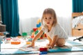 Baby girl playing indoors sitting on floor in playroom at home with constructor. Educational game for baby and toddler Royalty Free Stock Photo