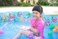 Baby girl playing in kiddie pool