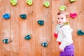 Baby girl playing next to a climbing wall Royalty Free Stock Photo