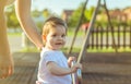 Baby girl playing over a seesaw swing on the park