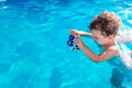 Baby girl playing in the pool with a plastic toy in summer in the sun with copy space Royalty Free Stock Photo