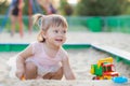 Baby girl playing in sandbox in kindergarten.ittle girl plays with toys in the sand.