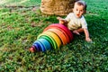 Baby girl playing with a waldorf material, a rainbow of wood montessori, in nature