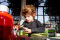 Baby girl plays baby crafts on an art table