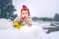 Baby girl plays with the snow lying