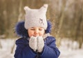 Baby girl plays with snow in winter on a sunny day Royalty Free Stock Photo